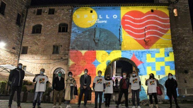 Porta Consolare illuminata con i colori dell’iniziativa di beneficenza “Spello nel cuore”